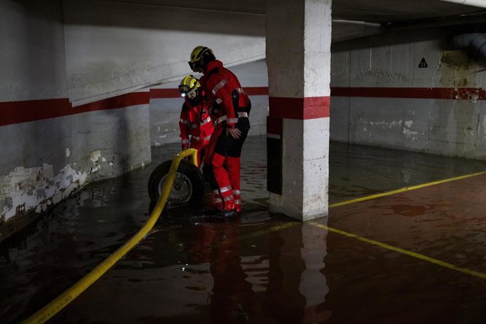 Operarios trabajando el pasado martes en una inundación en un garaje particular de Terrassa por las lluvias