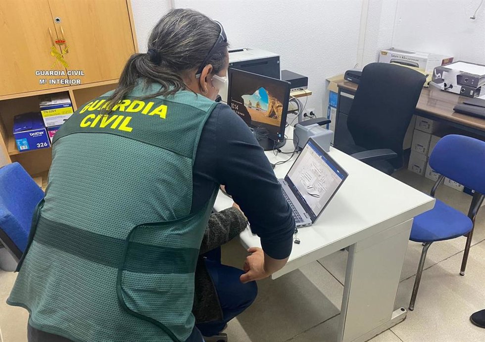 Archivo - Una agente de la Guardia Civil revisa material informático