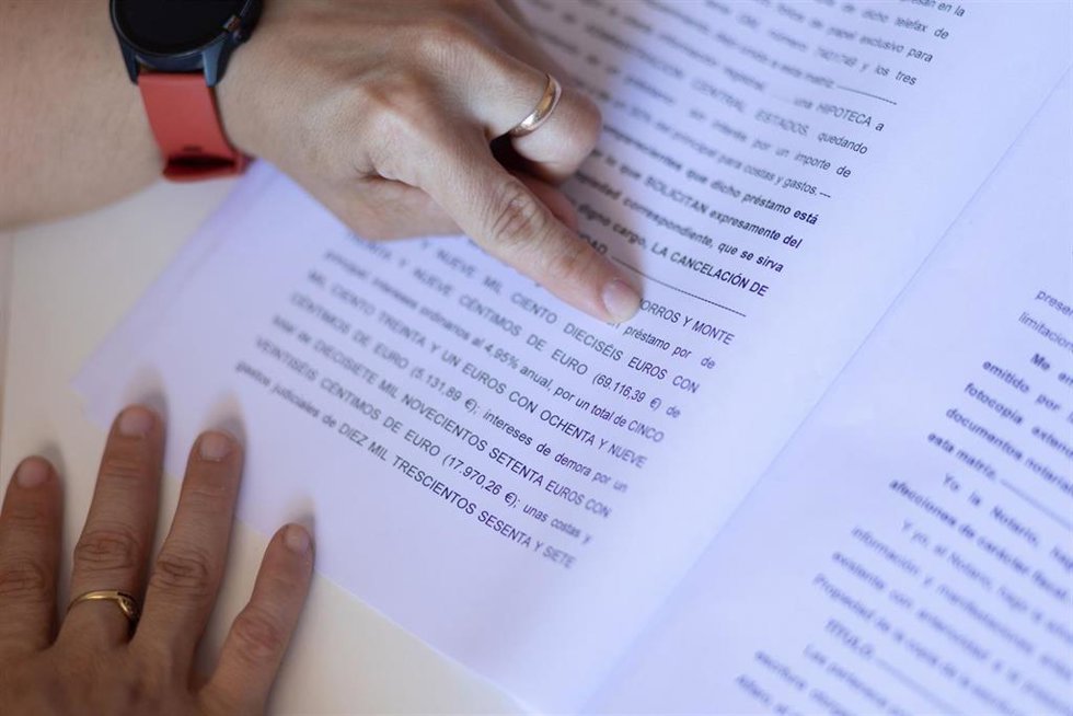 Archivo - Una mujer señala una escritura de compraventa de una hipoteca, a 30 de mayo de 2022, en Madrid (España).  