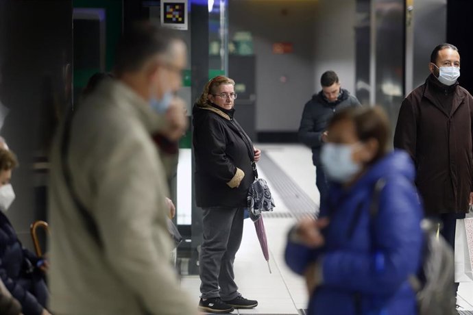 Archivo - Varias personas con y sin mascarillas en el interior del metro. 