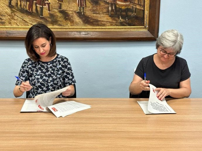 La alcaldesa de Ejea de los Caballeros, Teresa Ladrero, firma el acuerdo con la representante de IU.