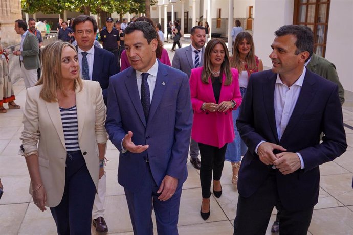 El presidente de la Junta de Andalucía, Juanma Moreno (c), llegando al pleno junto a la próxima alcaldesa de Granada, Marifrán Carazo (i) y el próximo alcalde de Cádiz, Bruno García (d), en una foto de archivo en el Parlamento andaluz.