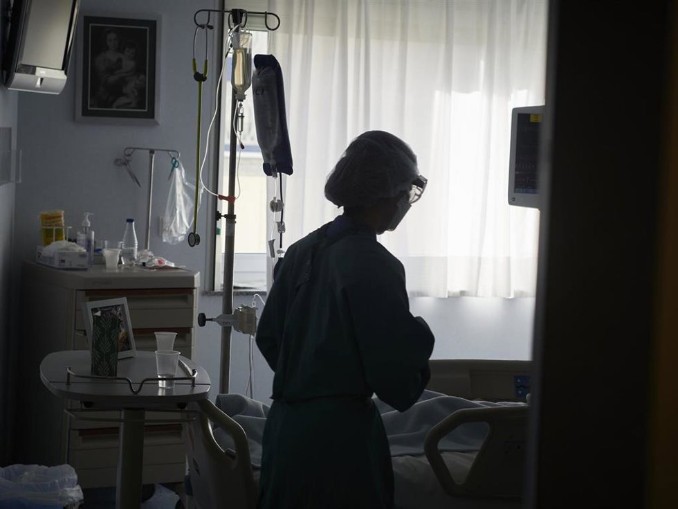 Archivo - Un trabajador sanitario atiende a un paciente en una camilla de la UCI de la Clínica Universidad de Navarra, en Pamplona, Navarra, (España), a 10 de noviembre de 2020. La situación actual de las UCI, ahora que la región pasa por la segunda ola