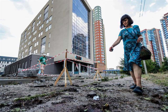 Archivo - August 8, 2022, Kharkiv, Kharkiv, Ukraine: A Ukrainian woman walks past a cordoned location where a man died in a Russian cluster-bomb attack.