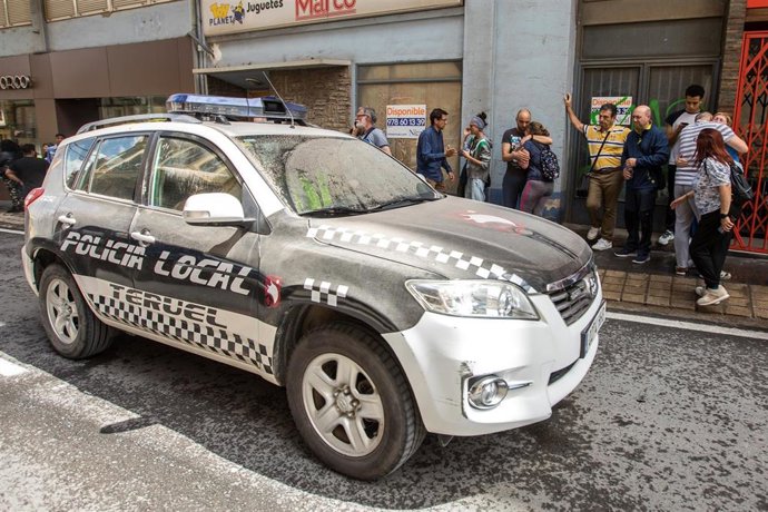 Un coche policial junto a un edificio de cinco plantas situado en la calle San Francisco de Teruel tras derrumbarse por completo.