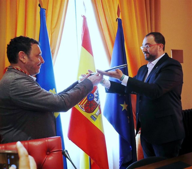 El presidente del Principado y exalcalde de Laviana, Adrián Barbón, entrega el bastón de mando al alcalde Julio García.