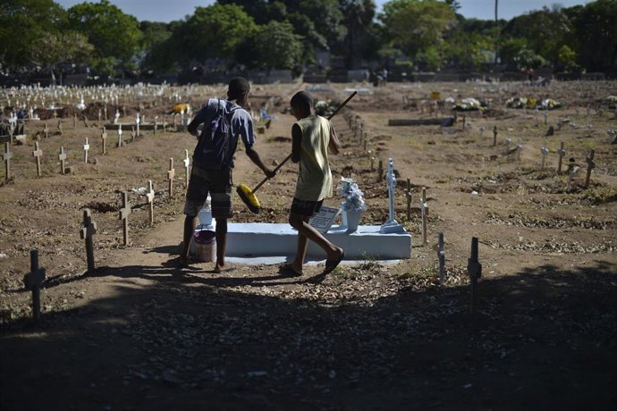 Archivo - Niños limpiando y pintando tumbas en  un cementerio de Rio de Janeiro (Brasil)