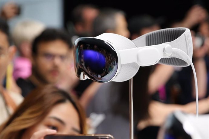 05 June 2023, US, Cupertino: Media representatives and bloggers surround the Apple Vision Pro computer glasses on display in the Steve Jobs Theater on Apple's corporate campus in Cupertino. 