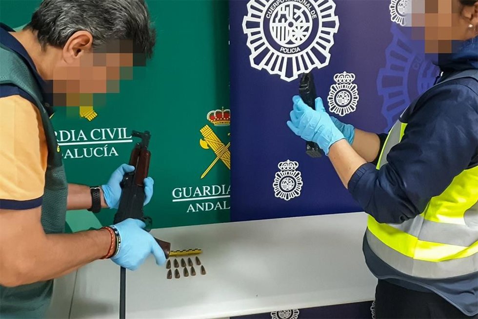 Agentes de la Guardia Civil y la Policía Nacional con una de las armas incautadas en la operación.