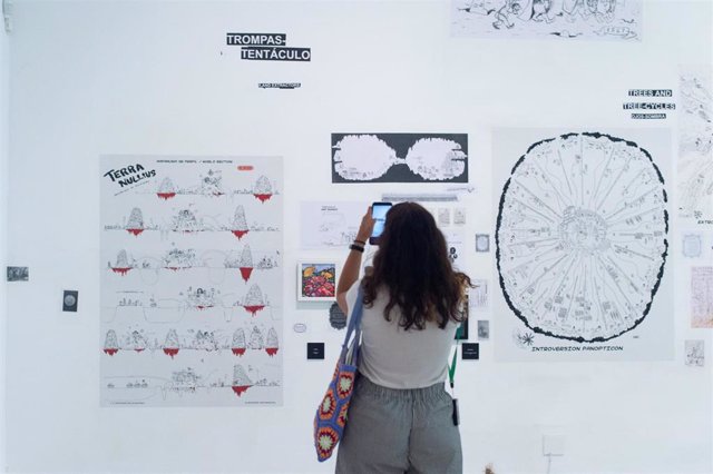 Una joven fotografía una de las obras de la exposición 'Maquinaciones', en el Museo Reina Sofía