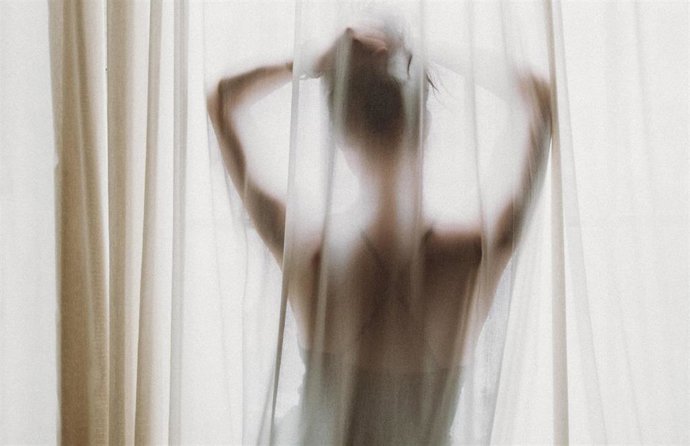 Una mujer al otro lado de un visillo