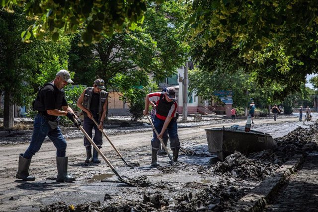 Personal de trabajo retira el lodo dejado por las inundaciones, en Jersón, Ucrania.