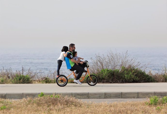 Archivo - BEIRUT, April 18, 2022  -- A man with two children rides a tricycle on a coastal road in Beirut, Lebanon, on April 18, 2022.