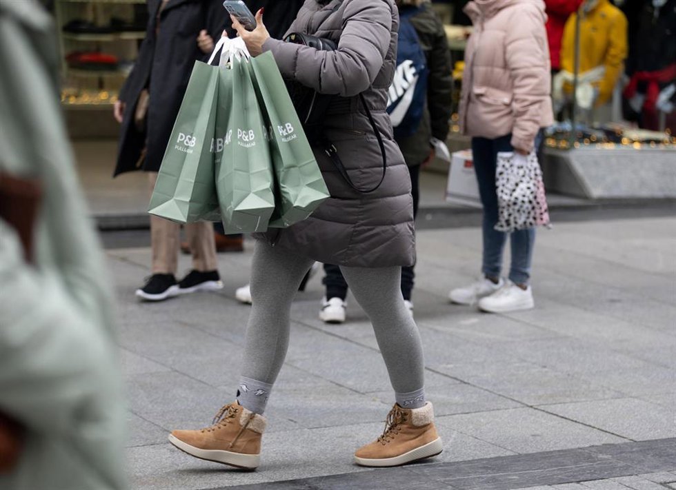 Archivo - Una persona sujeta varias bolsas con compras en Madrid (España). 