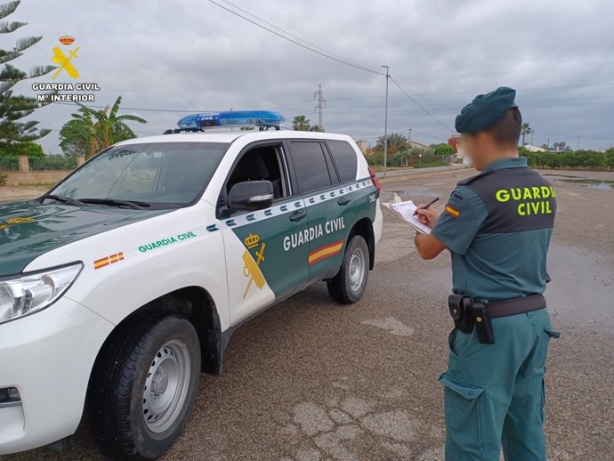 Agente de la Guardia Civil junto a un vehículo. Archivo.