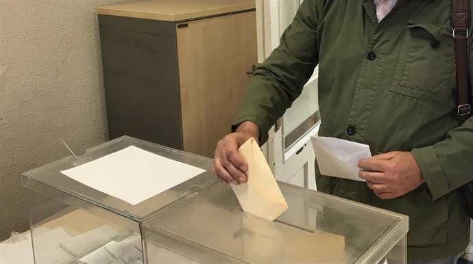 Un hombre deposita su voto en una urna en unas elecciones.