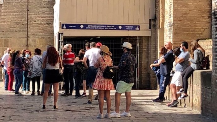 Turistas en la entrada a la Catedral y la Giralda de Sevilla.