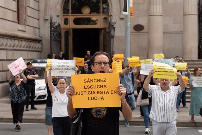 Unos 40 funcionarios de Justicia sujetan pancartas durante una protesta ayer frente a la Audiencia de Barcelona.