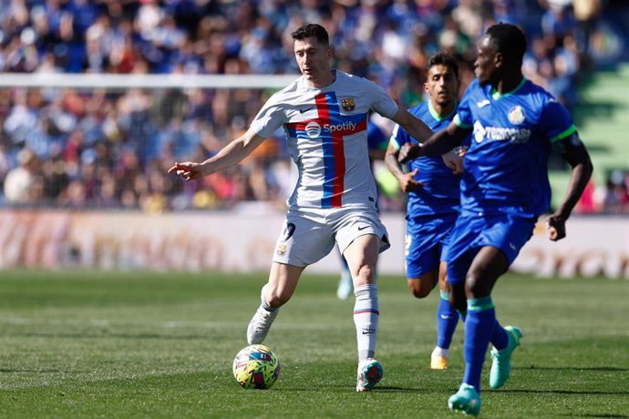 Archivo - Robert Lewandowski ante Djené en el Getafe-FC Barcelona de la Primera División 22-23