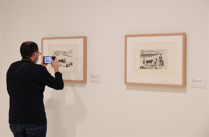 Un hombre fotografía con su teléfono móvil un dibujo de Picasso en  la exposición Goya/Picasso. TauroPaquia, en la Real Academia de Bellas Artes de San FernandO