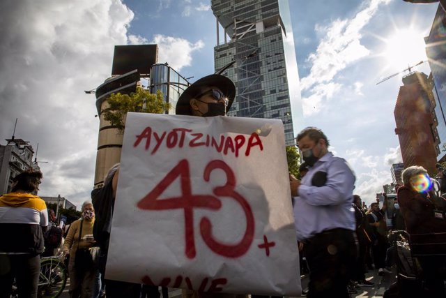 Archivo - Un hombre sostiene una pancarta durante una protesta para exigir justicia por la muerte de los 43 normalistas de Ayotzinapa