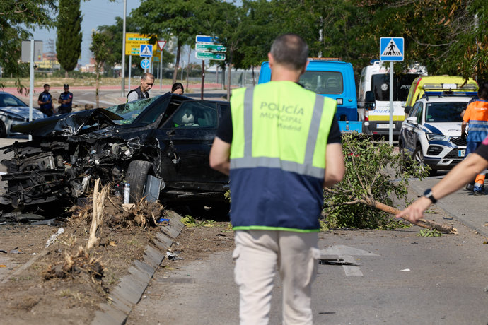 Un agente de policía municipal se acerca al coche siniestrado de la víctima mortal, en el barrio de Villaverde, a 23 de junio de 2023, en Madrid (España). 
