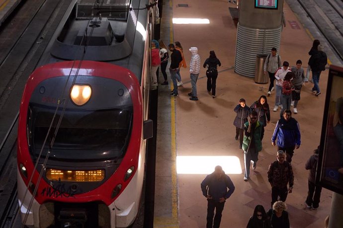 Archivo - Varias personas en el andén de un tren de cercanías en la estación Almudena Grandes-Atocha Cercanías.