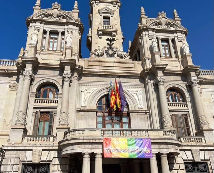 La fachada del Ayuntamiento de Valncia luce, con motivo de la celebración del Orgullo LGTBIQ+, la pancarta de la campaña municipal de este año.