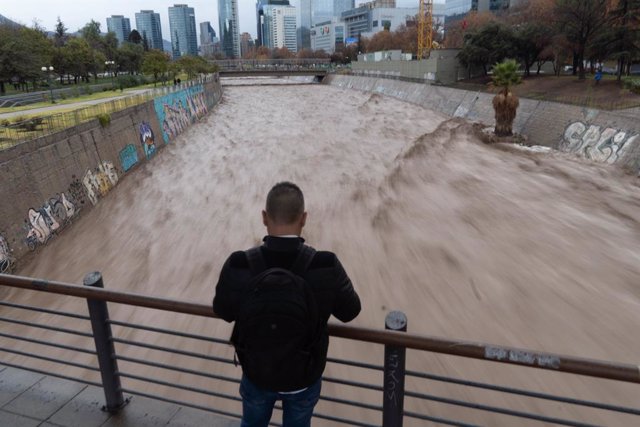 June 23, 2023, Santiago, Metropolitana, Chile: A woman watch the Mapocho river running high due to heavy rains in Santiago, Chile.