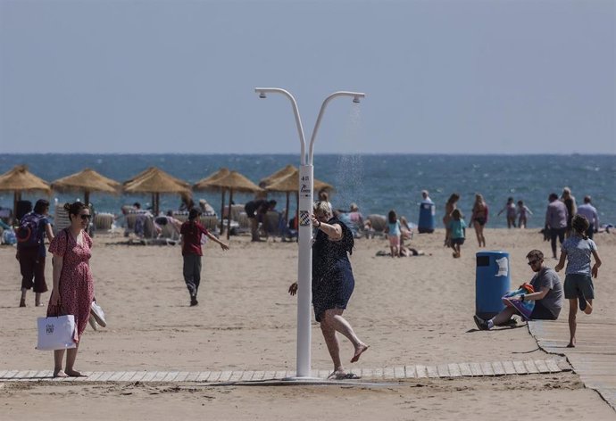 Archivo - Una persona usando la ducha de una playa