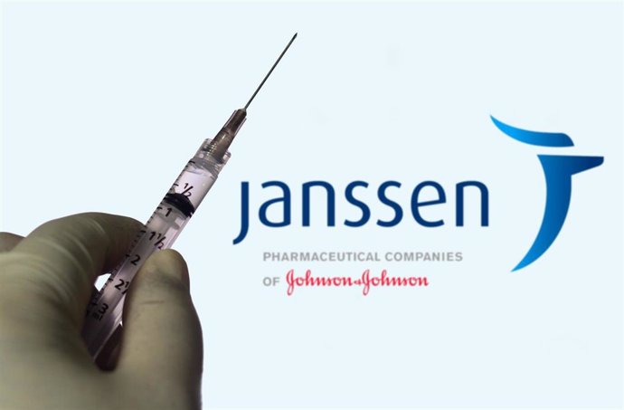 Archivo - March 30, 2021, Brazil: In this photo illustration, a hand holds a medical syringe with a Janssen Pharmaceuticals company logo displayed on a screen in the background.