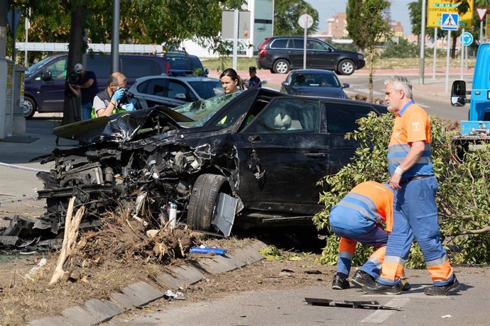 Un agente de la policía toma fotografías del coche siniestrado de la víctima mortal, en el barrio de Villaverde, a 23 de junio de 2023, en Madrid (España). 