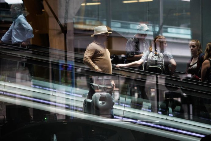Varias personas en unas escaleras mecánicas de la Terminal T4 del Aeropuerto Adolfo Suárez-Madrid Barajas, a 21 de junio de 2023, en Madrid (España). 
