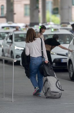 Archivo - Una mujer con una maleta en la fila de los taxis 