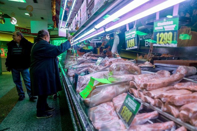 Archivo - Personas realizando compras en un mercado