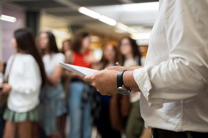 Un professor subjecta una pila d'exmens abans de comenar les proves d'accés a la universitat 2023.