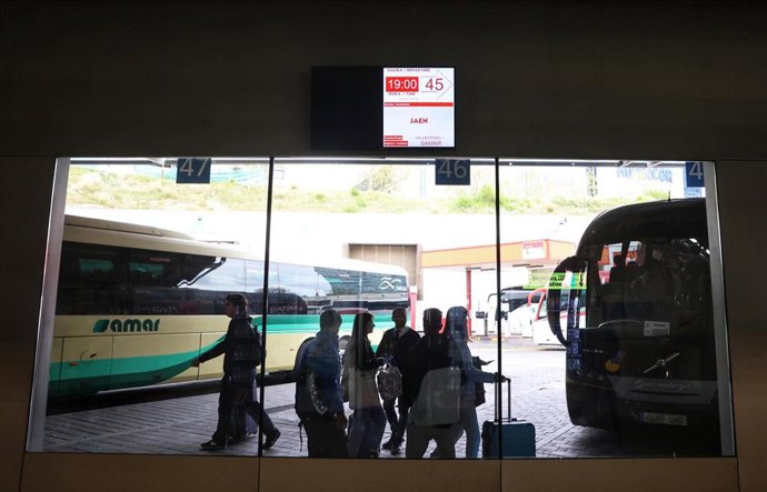 Archivo - Un grupo de personas frente a un autocar en las inmediaciones de la estación de autobuses de Méndez Álvaro