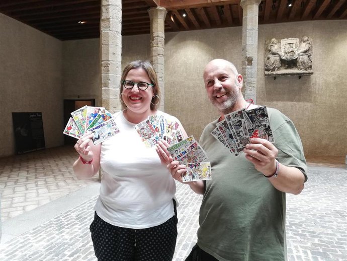 Marta Aparicido y Iosu Santxez con las pancartas de las peñas para los Sanfermines de 2023.