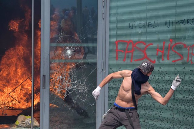 29 June 2023, France, Nanterre: A protester clashes with police during a commemoration march for a teenage driver shot dead by a policeman, in the Parisian suburb of Nanterre. Riots broke out again in the French town of Nanterre following a march calling 