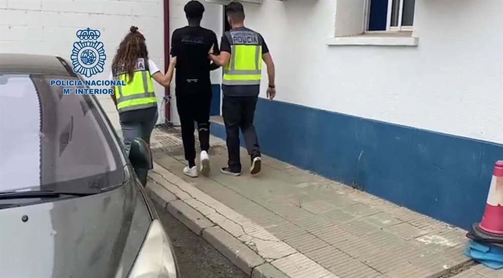 Agentes de la Policía Nacional junto a uno de los detenidos por presuntas estafas