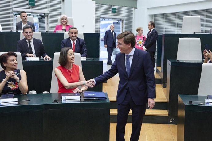 La exministra de Industria, Comercio y Turismo, Reyes Maroto, y el alcalde de Madrid, José Luis Martínez-Almeida (PP), se saludan en la sesión de constitución del Ayuntamiento de Madrid