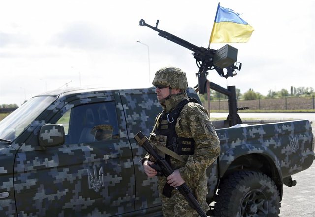 Archivo - Militar con un vehículo y una bandera de Ucrania en una imagen de archivo