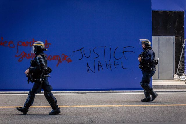 Policías antidisturbios frente a una pintada pidiendo "Justicia para Nahel" en París, Francia