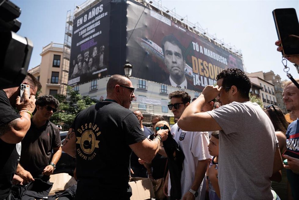 El líder de Desokupa, Dani Esteve (c), conversa el día en el que la plataforma Desokupa ha desplegado una lona en Atocha contra el presidente del Gobierno, a 3 de julio de 2023, en Madrid (España). La plataforma Desokupa ha desplegado un lona en la madr
