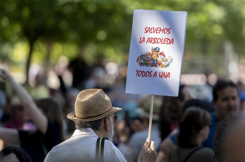 Archivo - Un hombre porta una pancarta que reza 'Salvemos la arboleda, todos a una' durante una manifestación a favor de la vegetación urbana y contra la destrucción de parques y la tala de árboles, en el Parque de Arganzuela 