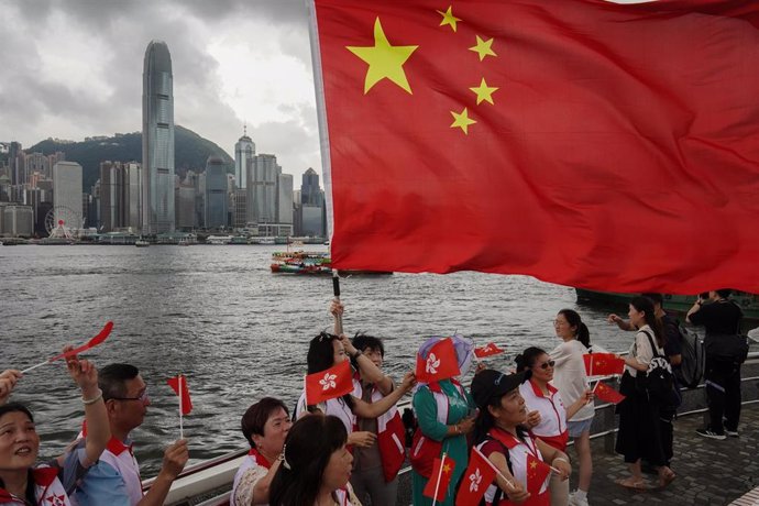 Manifestantes con banderas de chinas y hongkonesas conmemoran el 26 aniversario de la devolución de Hong Kong por parte de Reino Unido