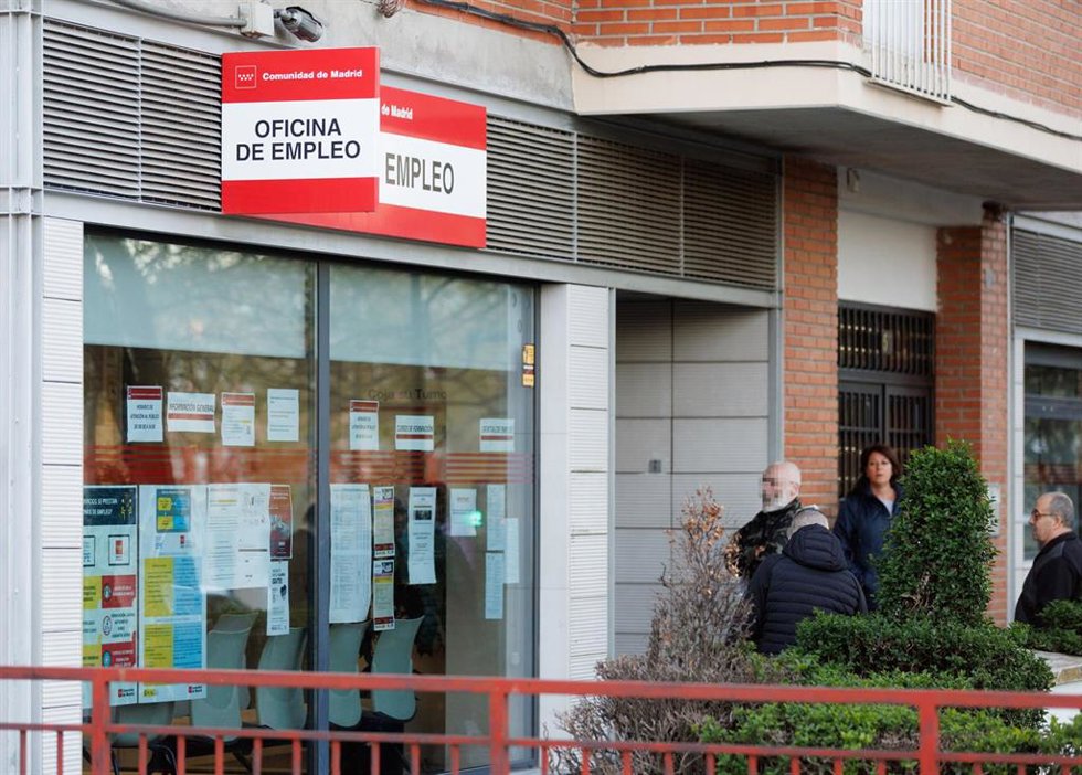 Archivo - Varias personas esperan en la entrada de una oficina del SEPE