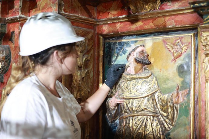 Una estudiante de Bellas Artes de la Universidad de Sevilla, en los trabajos de restauración en el retablo de la Iglesia Santiago el Mayor de Sevilla capital.