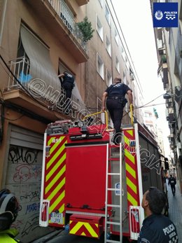 Imagen de los agentes, accediendo a la casa con la ayuda de los Bomberos