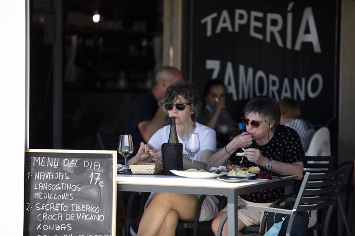 Archivo - Dos mujeres comen en una terraza del paseo marítimo de la playa de Sanxenxo, a 4 de junio de 2021, en Sanxenxo, Pontevedra, Galicia, (España). El aumento de las temperaturas y la progresiva mejora de la situación epidemiológica ha colaborado e